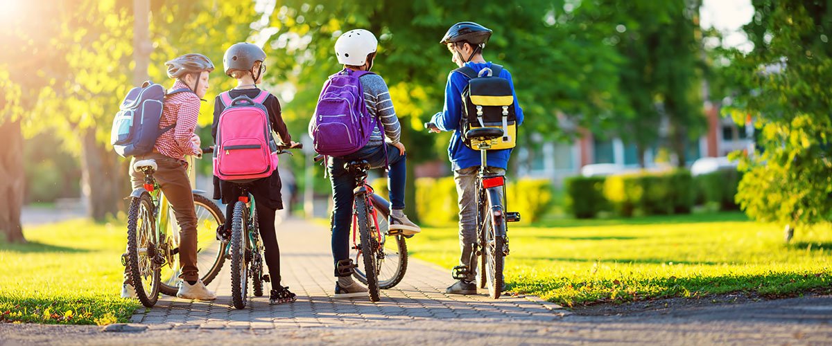 Students on bikes with helmets and backpacks