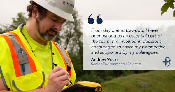 Andrew Wicks, Senior Environmental Scientist at Dawood, conducts fieldwork in a safety vest and hard hat while using a handheld GPS device. A quote overlay highlights his positive experience and collaborative role at Dawood.